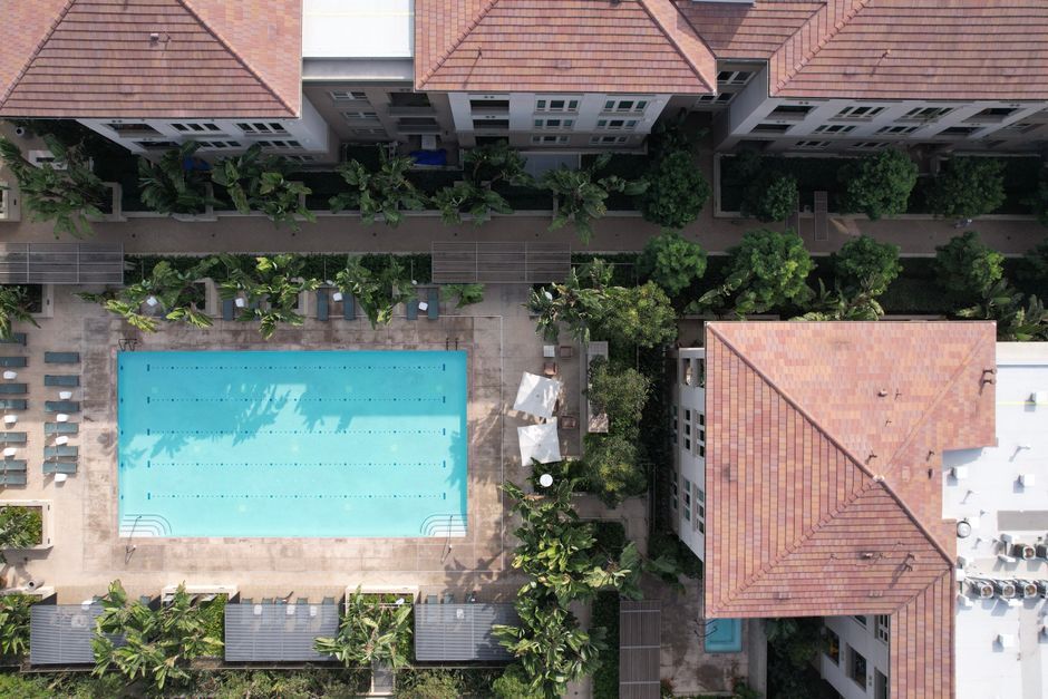 Top-down view of an apartment courtyard pool between tile-roofed buildings