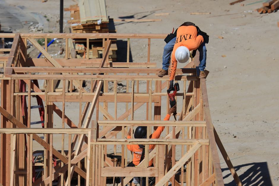 Crew framing a wooden structure at a construction site