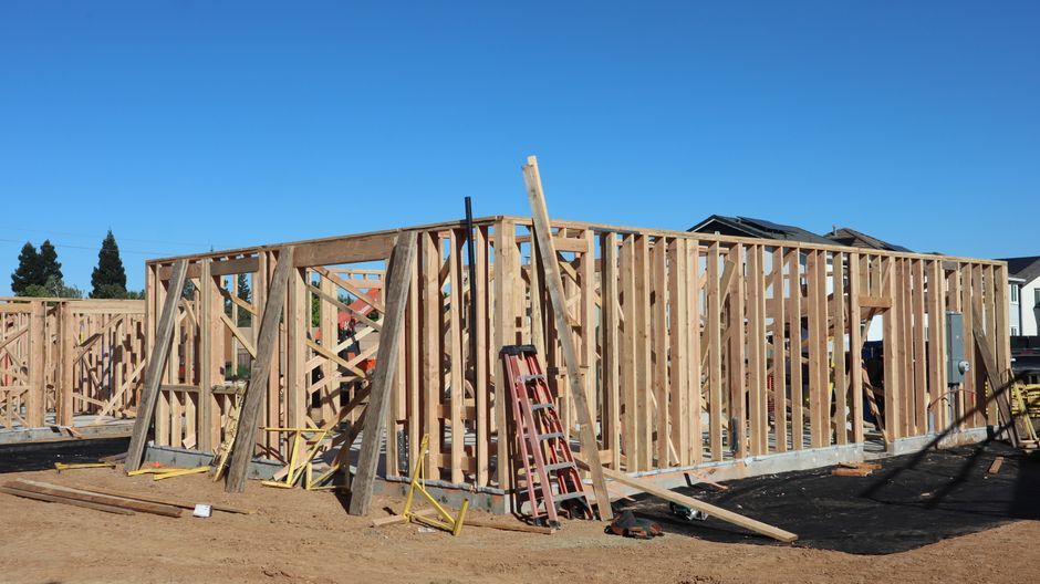 Framed wooden walls and ladders at a construction site
