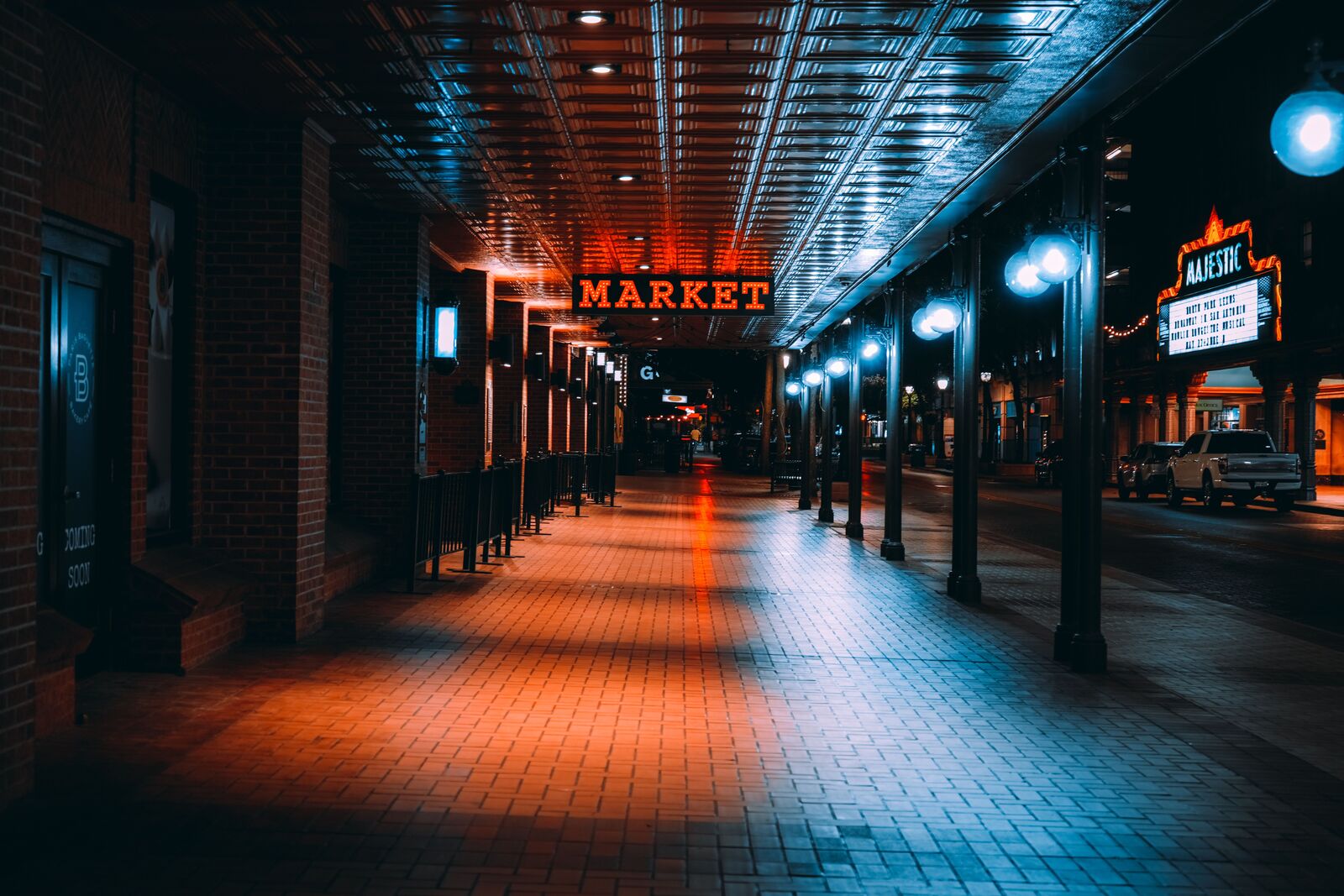 Covered arcade with market signage in downtown San Antonio at night