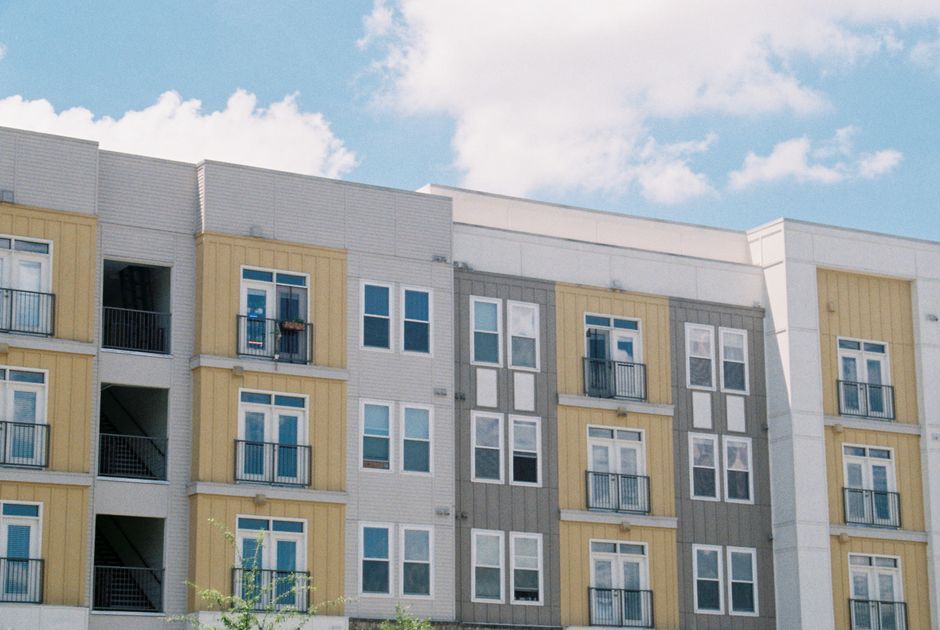 Crisp new apartment building exterior with balconies under a blue sky